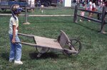 Blindfolded Boy Pushing Wheelbarrow. by Richard Hoffman