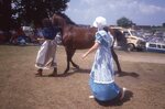 Women Lead Horse on Festival Grounds by Richard Hoffman