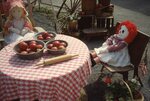 Dolls Sitting at Table on Festival Grounds by Richard Hoffman