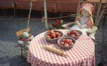 Doll and Bear Sitting At Table on Festival Grounds by Richard Hoffman