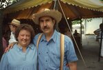 Couple Pose Near Vendor's Tent on Festival Grounds by Richard Hoffman