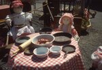 Dolls Sit Around Table on Festival grounds. by Richard Hoffman