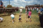 Children Play on Wooden Wagon Frame on Festival Grounds by Richard Hoffman