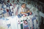 Man Stands Between Rows of Quilts in Quilt Barn by Richard Hoffman
